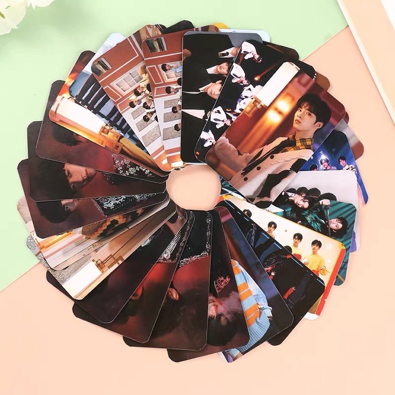 Fan of K-pop photocards featuring various members in different outfits and poses, arranged in a circular fan shape.