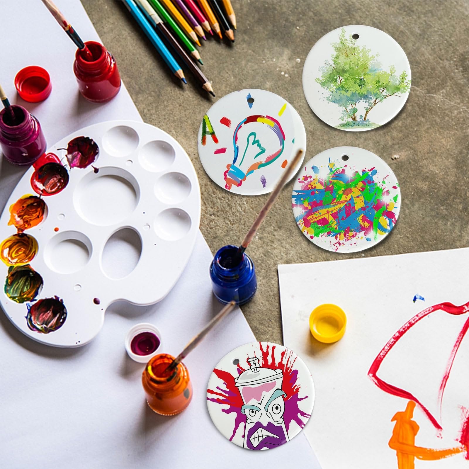 Round ceramic sublimation ornament blanks with art supplies and colorful designs