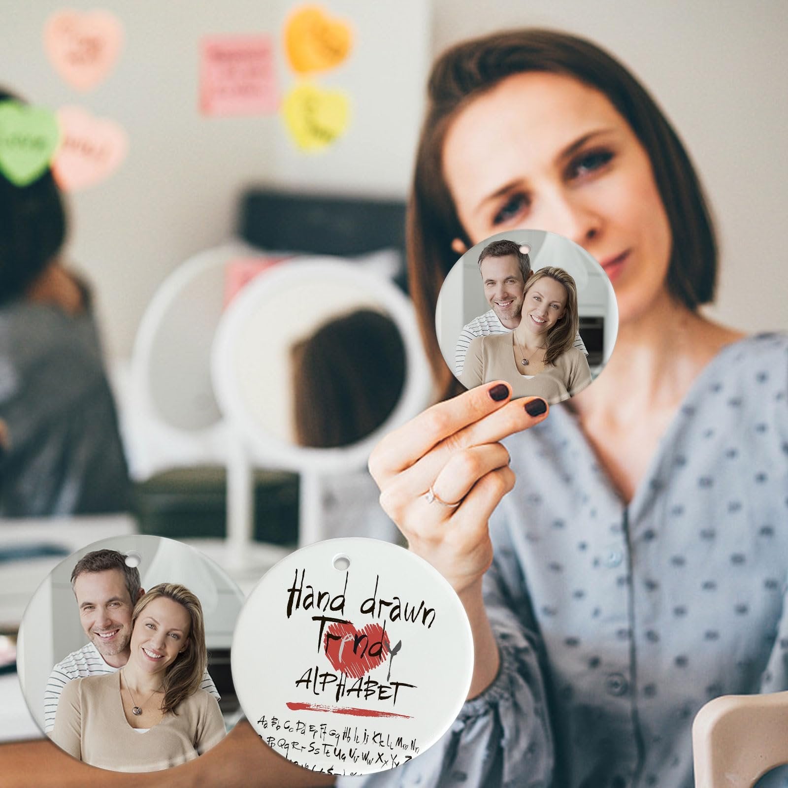 Woman holding two round ceramic sublimation ornament blanks, one with a couple's photo, the other with 'Hand drawn alphabet' text.