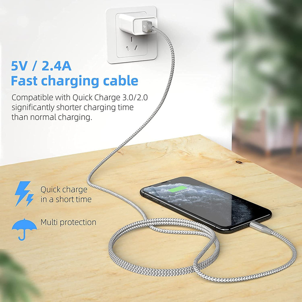 Braided grey and white charging cable plugged into a phone and wall adapter on a wooden surface.