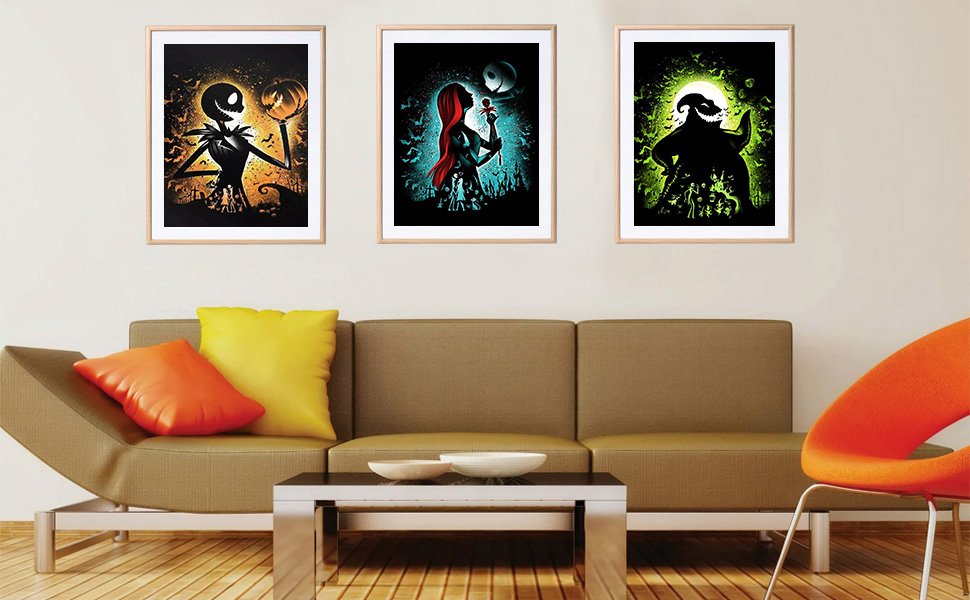Three framed Halloween-themed diamond art paintings displayed on a living room wall above a sofa.