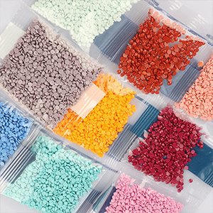 Assortment of small, colorful diamond art beads in clear plastic bags, arranged in a grid pattern.