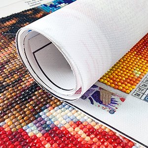 Rolled up Halloween 5D diamond art kit canvas showing colorful gem beads and grid pattern. Close-up view.