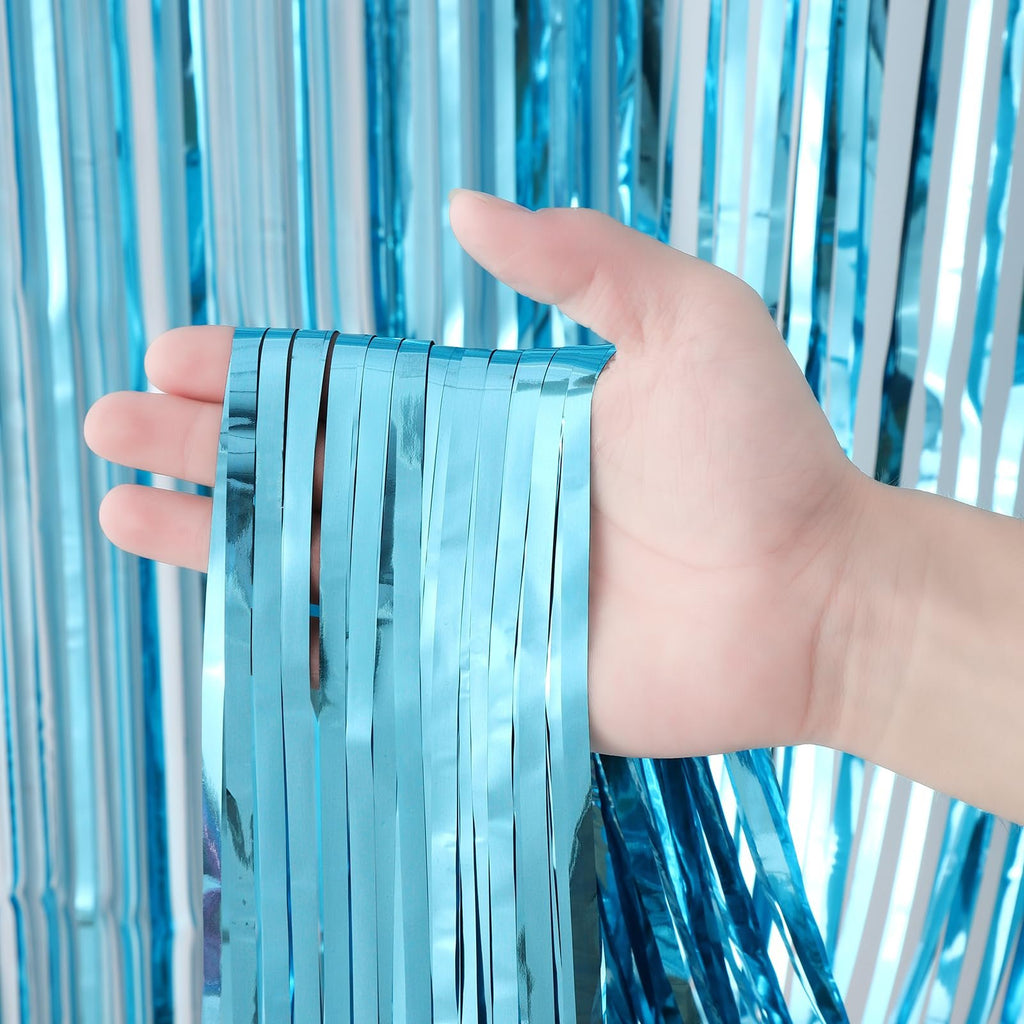 Hand holding light blue foil fringe backdrop curtain strands