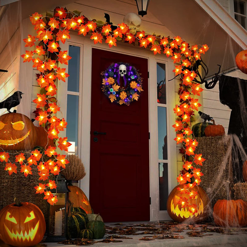 Halloween decorated porch with maple leaf string lights, pumpkins, and a skull wreath on the door.