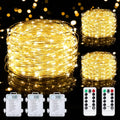 Three spools of warm white LED fairy string lights with battery packs and two remote controls against a bokeh background.