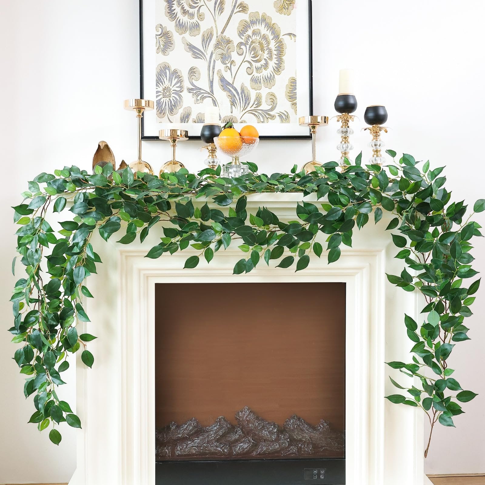 Artificial ficus vine garland draped over a fireplace mantel with decorative items