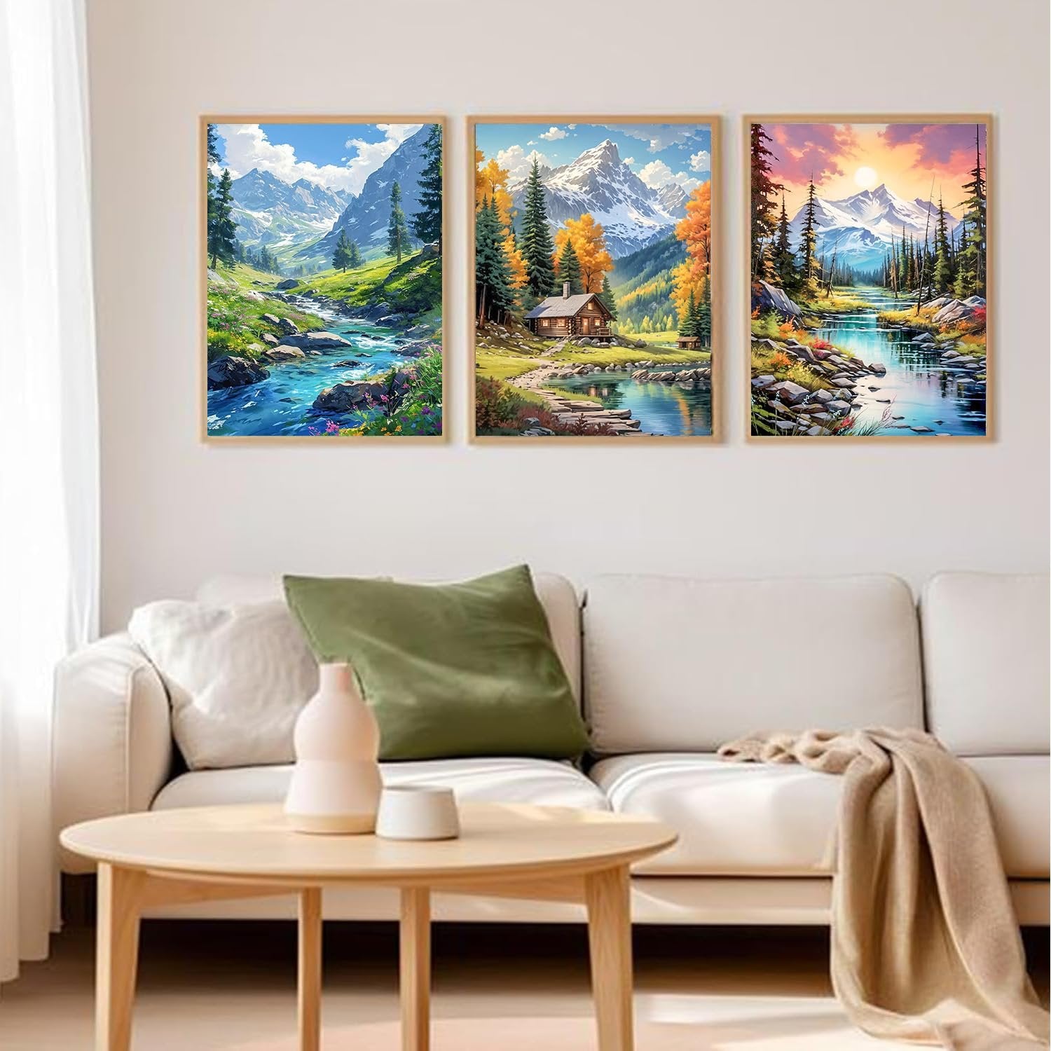 Three framed landscape diamond paintings displayed on a wall above a sofa.