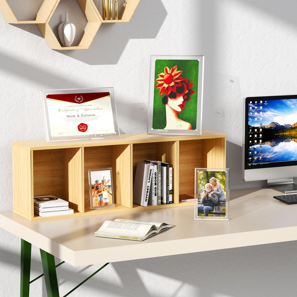 Three clear acrylic picture frames displayed on a desk with a certificate, artwork, and photos, next to a computer.