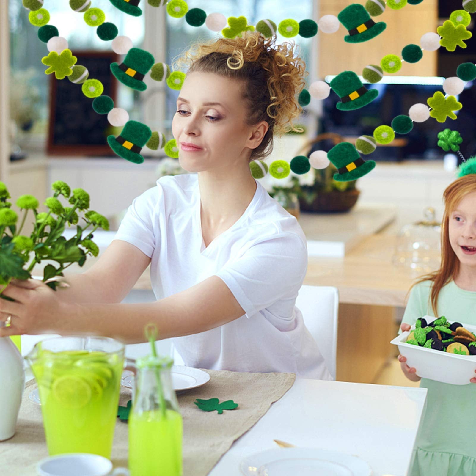 Woman and child at a table with St. Patrick's Day garland featuring shamrocks and leprechaun hats