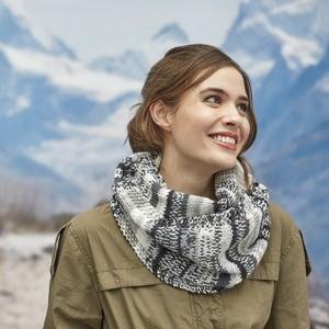 Woman wearing a knitted cowl made from Aran yarn against a snowy mountain backdrop.