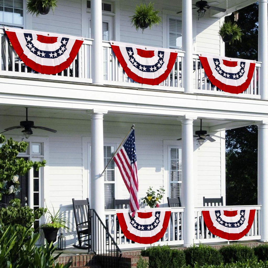 American pleated fan flags displayed on a white house porch with an American flag and rocking chairs.