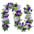 Artificial purple and lavender rose flower garland with green leaves on a white background
