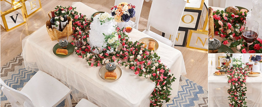Table setting with artificial rose garlands, cupcakes, wine, and decorative blocks spelling 'LOVE'