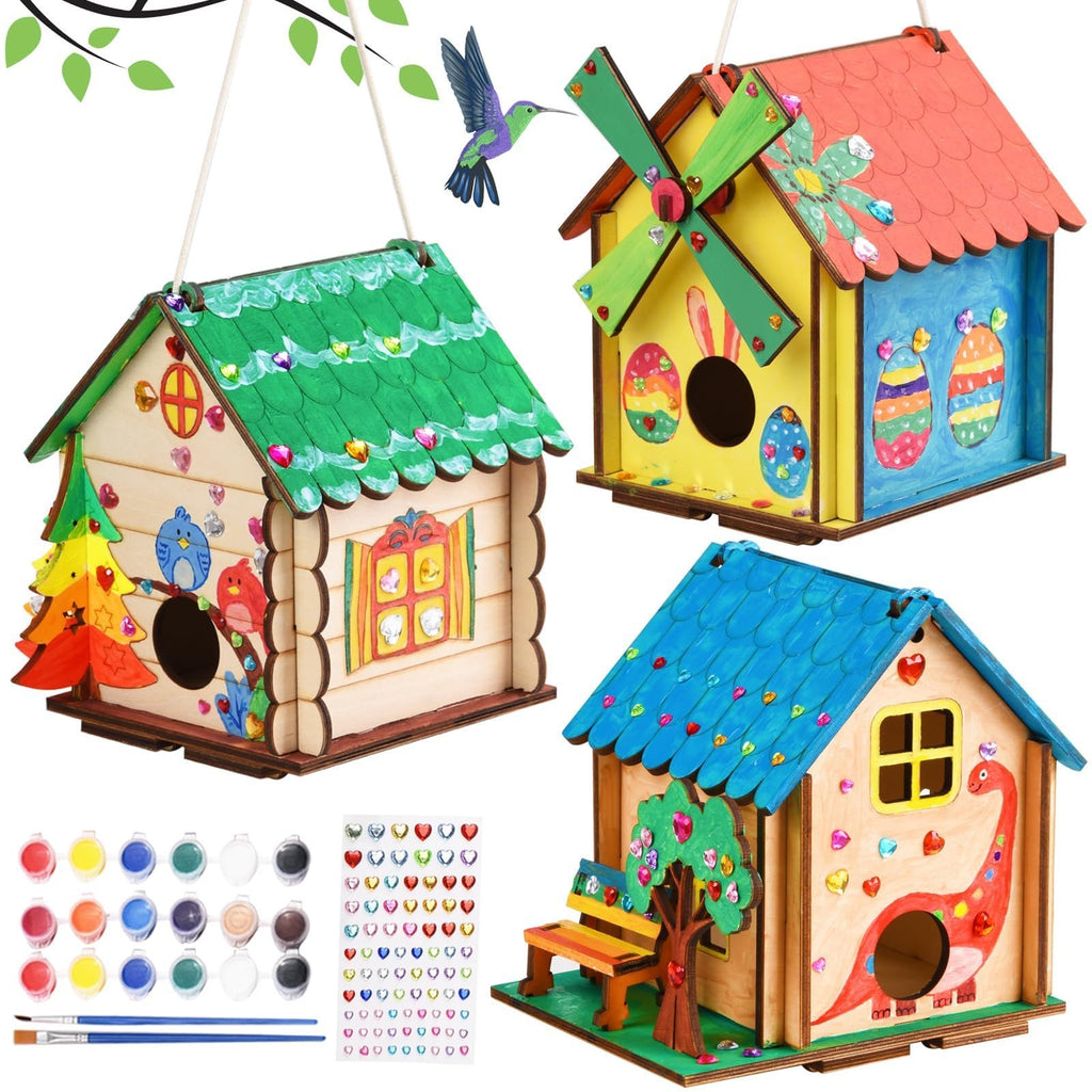 Three decorated wooden birdhouse craft kits with paints, brushes, and stickers shown.