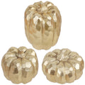 Three gold faceted resin pumpkins on a white background, arranged in a cluster.