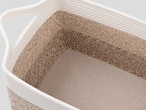 Close-up interior view of a gradient yellow woven storage basket with white rope handles and trim, showing textured cotton rope construction.
