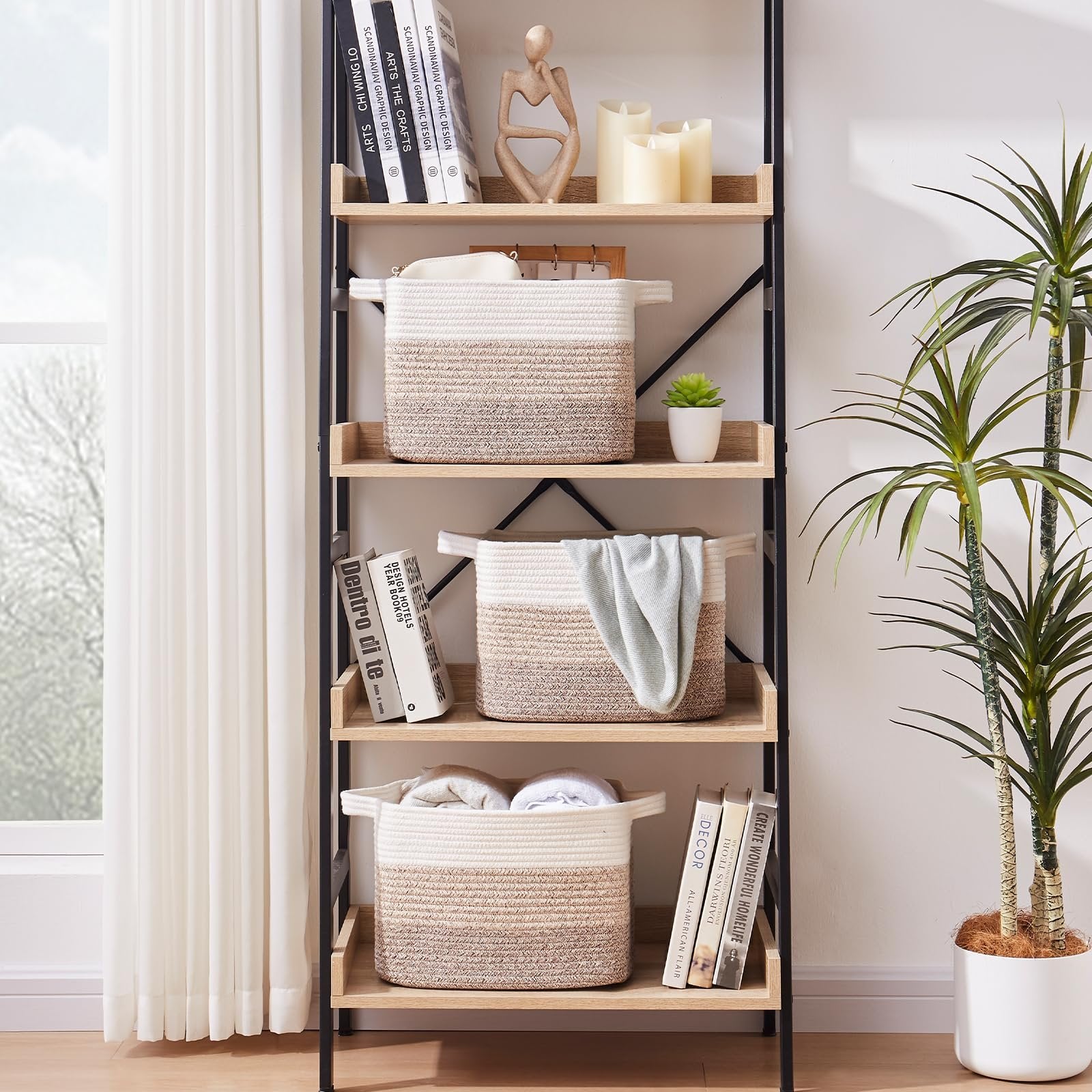 Three woven storage baskets with gradient yellow and white stripes on a bookshelf, one with a light blue blanket.