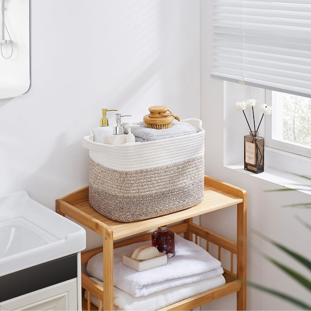 Woven storage basket with gradient yellow and white pattern filled with towels and soap dispensers on a wooden shelf.