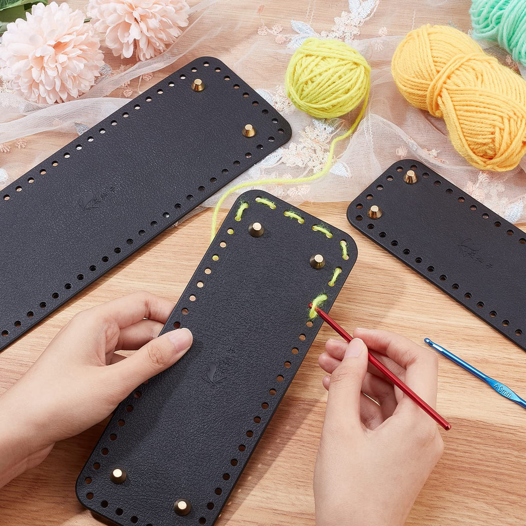 Three black leather purse bottoms with pre-punched holes and brass feet, one being crocheted with yellow yarn and a red hook.