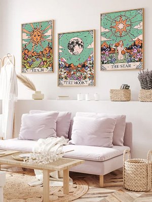 Three framed tarot-themed diamond art paintings of the sun, moon, and star hanging on a wall above a sofa.