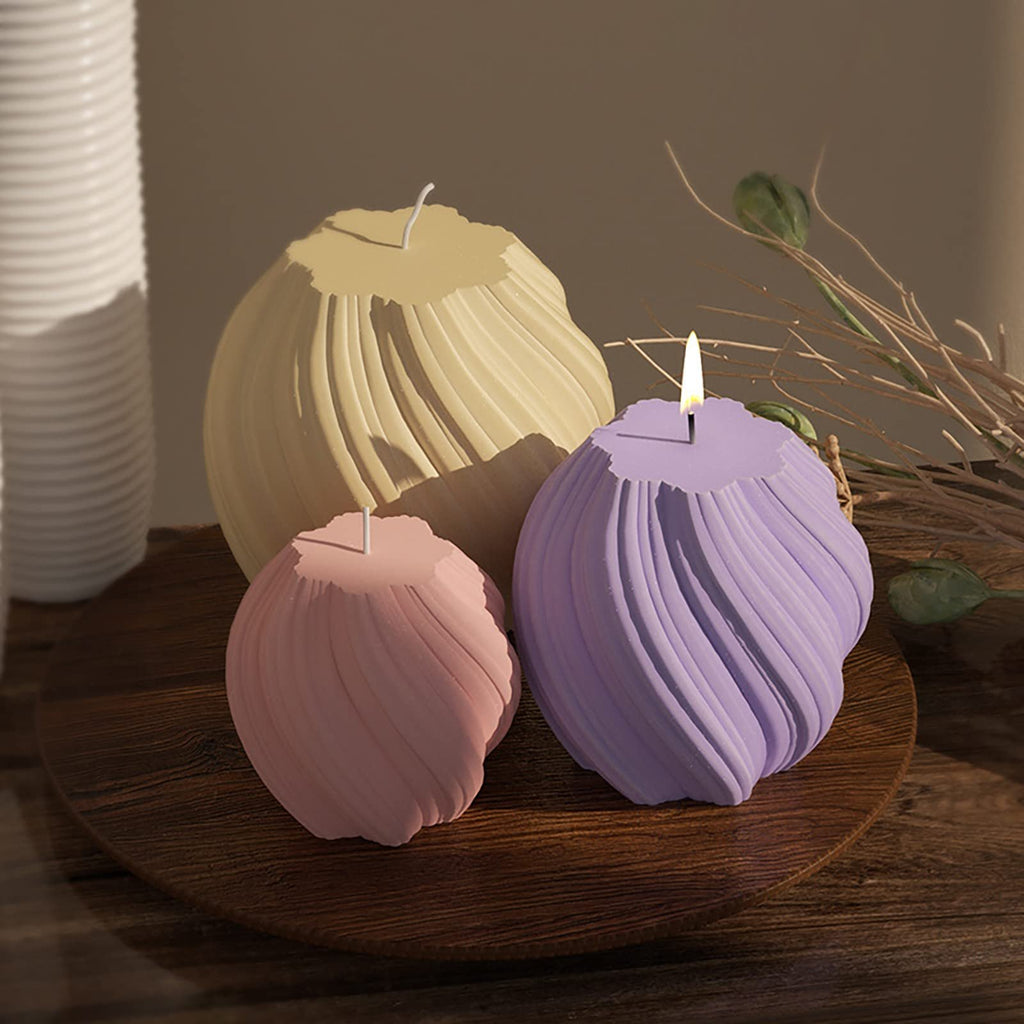Three pastel-colored wavy silicone molds for candles or soap on a wooden platter.