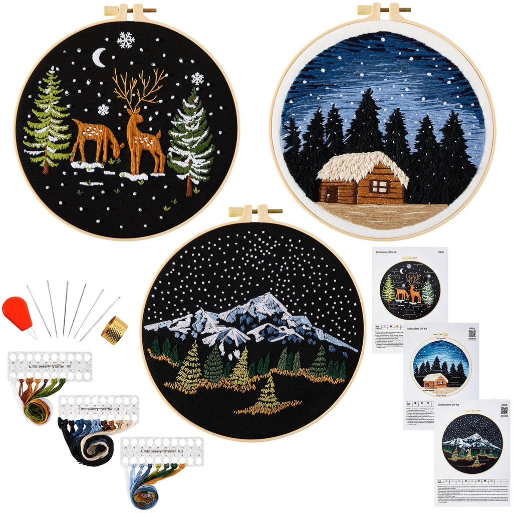 Three embroidered hoops with winter scenes, plus embroidery tools and thread organizers.