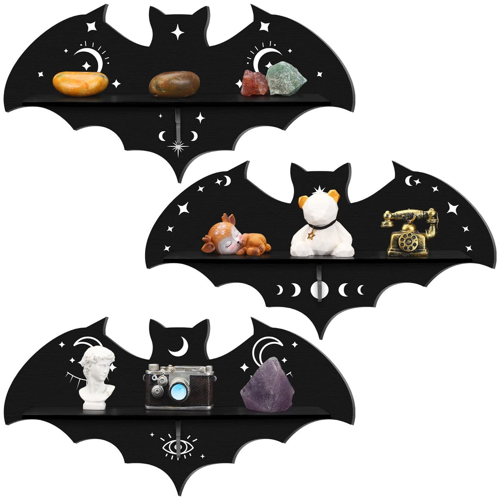 Three black wooden bat-shaped shelves with celestial and eye designs, each displaying decorative items.