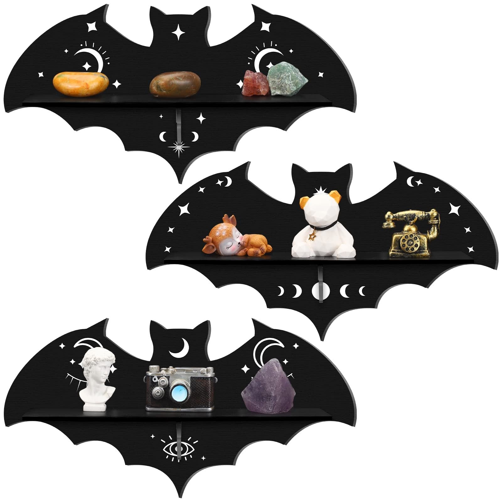Three black wooden bat-shaped shelves with celestial and eye designs, each displaying decorative items.