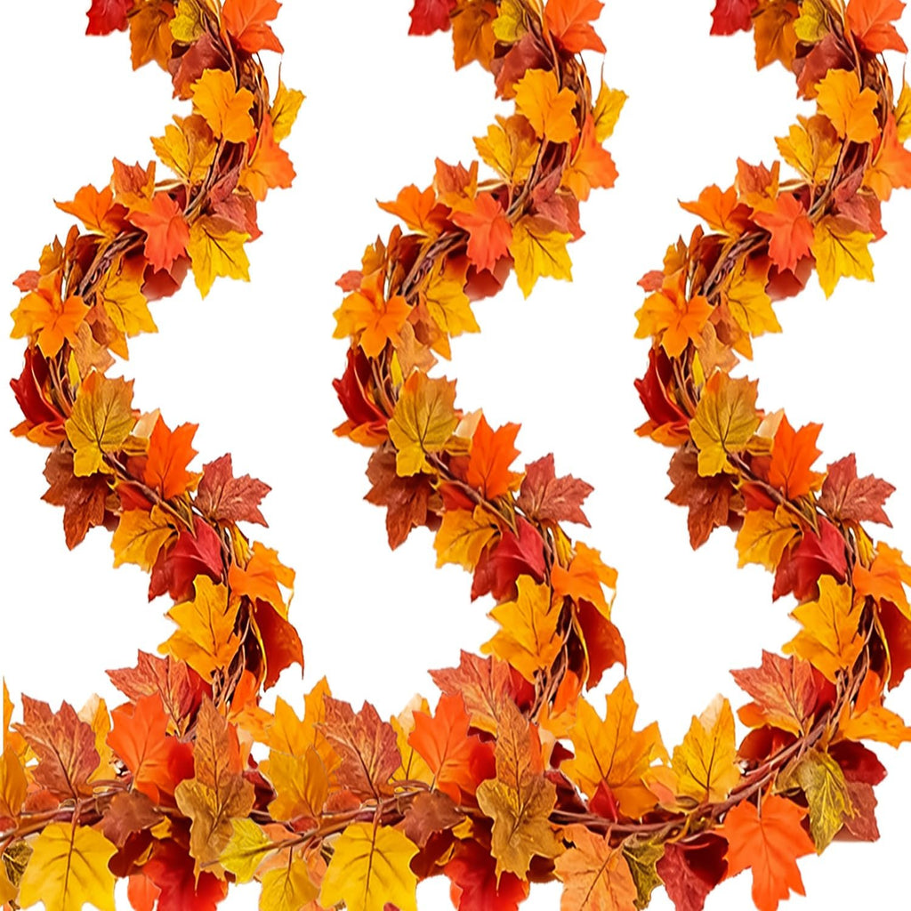 Three strands of faux fall maple leaf garland with red, orange, and yellow leaves on a white background.