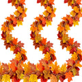 Three strands of faux fall maple leaf garland with red, orange, and yellow leaves on a white background.