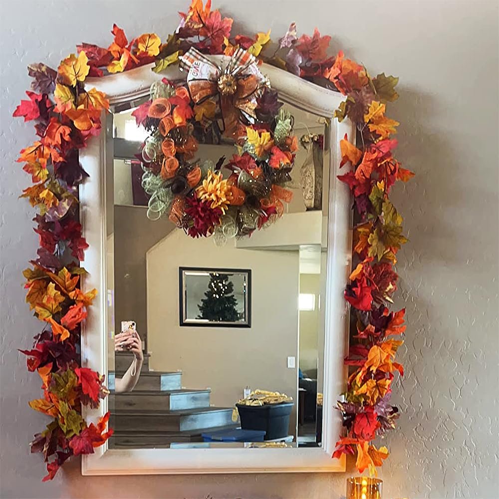 Autumn maple leaf garland draped around a mirror with a fall wreath hanging above it