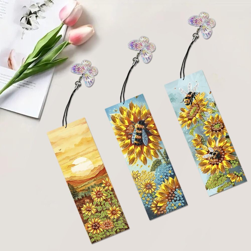Three diamond painting bookmarks with sunflower and bee designs, each with a butterfly charm.