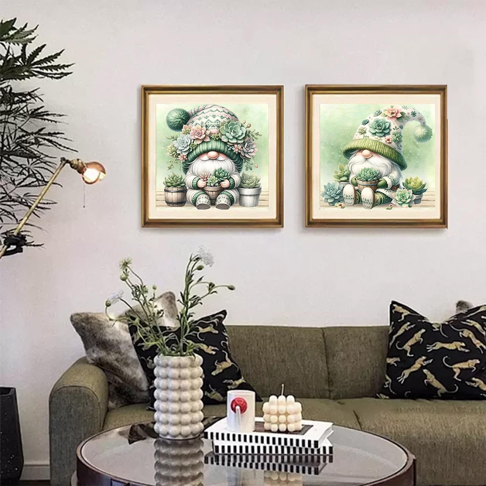 Two framed diamond art paintings of gnomes with succulents displayed on a wall above a sofa.