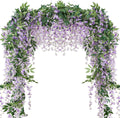 Artificial purple wisteria garland draped over an archway, featuring cascading faux flowers and green leaves.