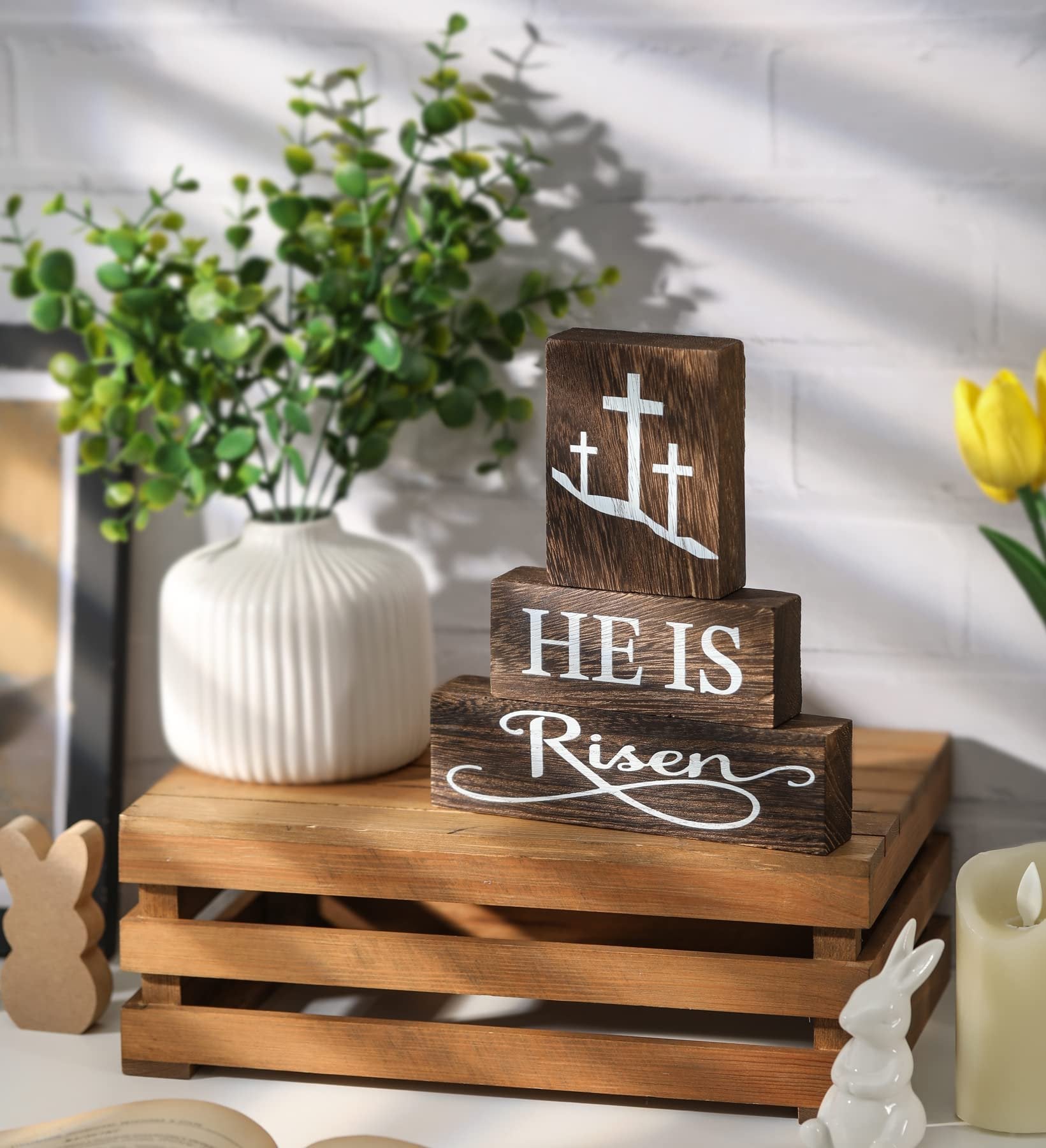 Three stacked wooden blocks with Christian Easter messages and crosses, displayed on a wooden crate with decorative elements.