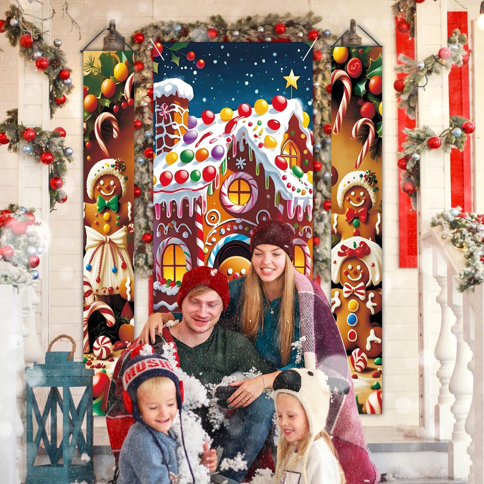 Family posing for a Christmas photo in front of gingerbread house and candy cane door banners