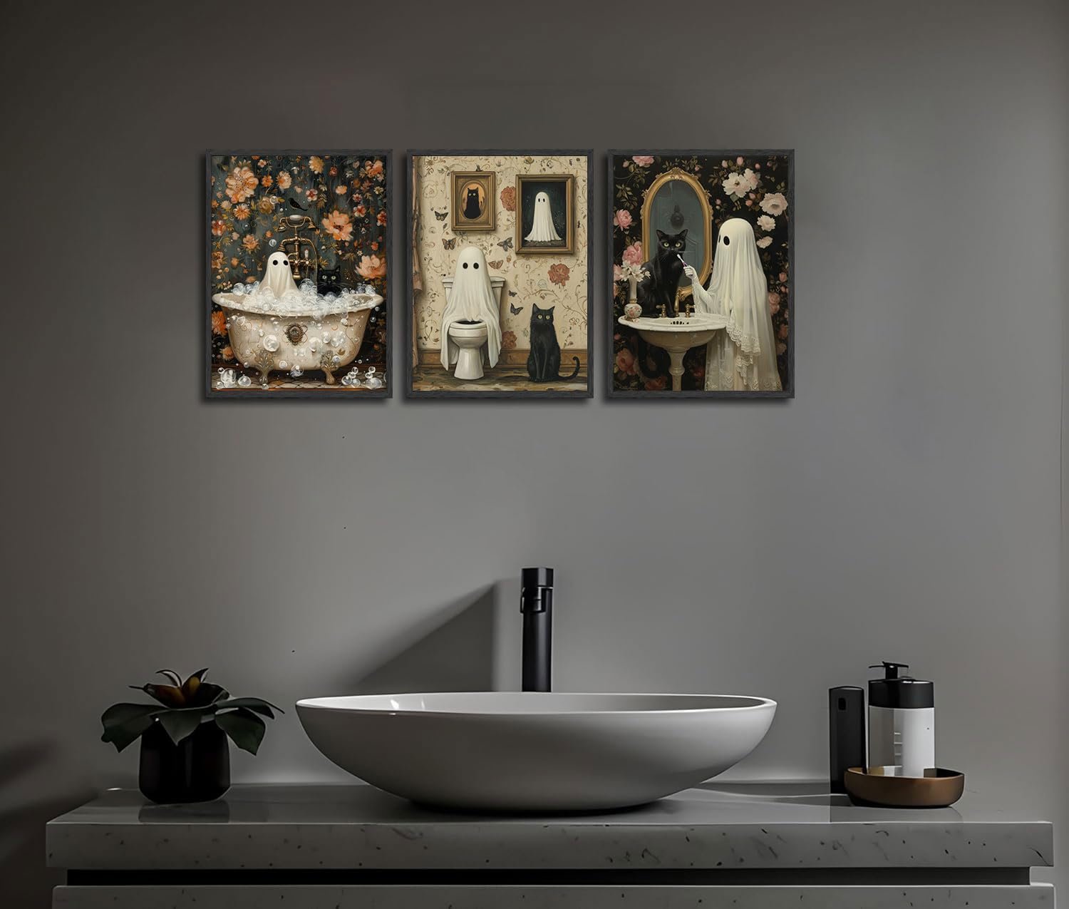 Three Halloween-themed canvas art prints featuring ghosts and black cats in a bathroom setting, displayed above a sink.