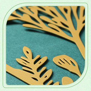 Close-up of gold metal floral wall art pieces with intricate leaf and branch designs against a teal background.