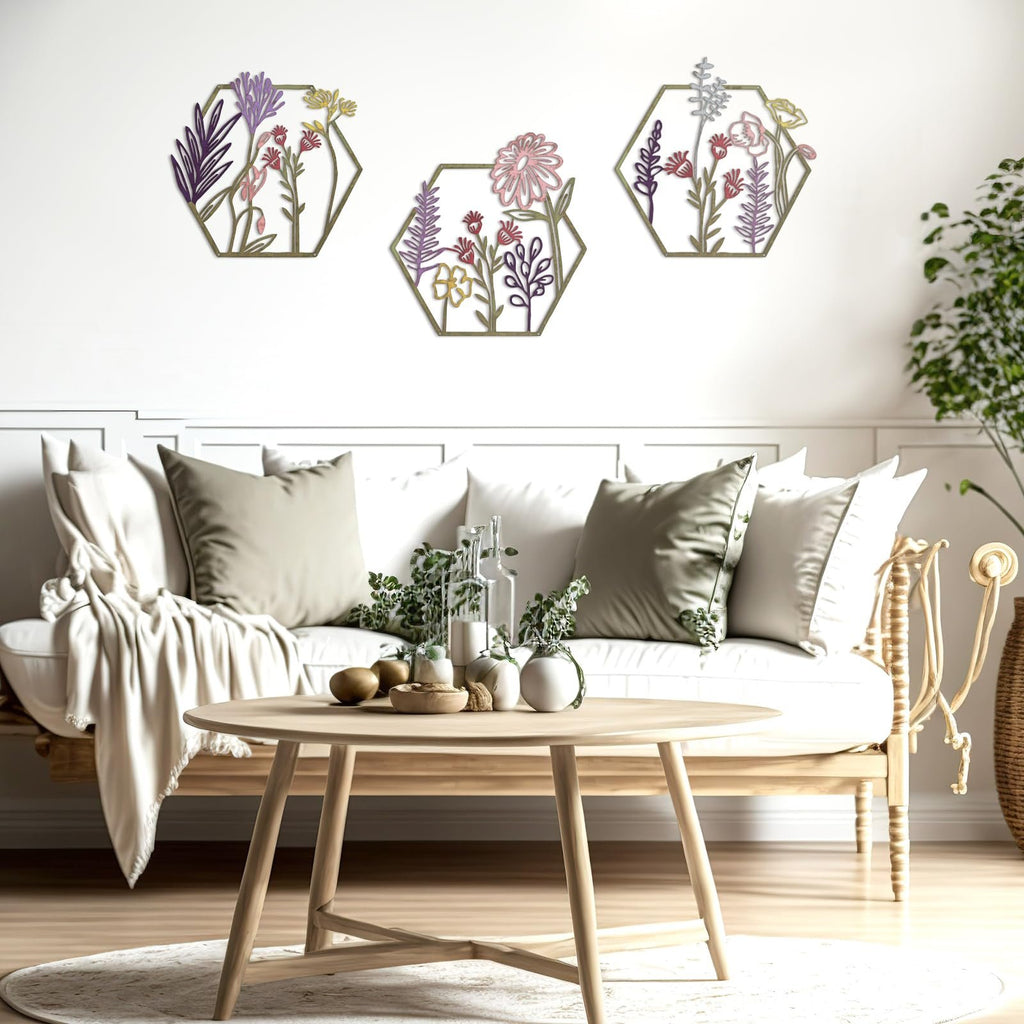 Three hexagonal metal flower wall art pieces displayed on a white wall above a sofa.
