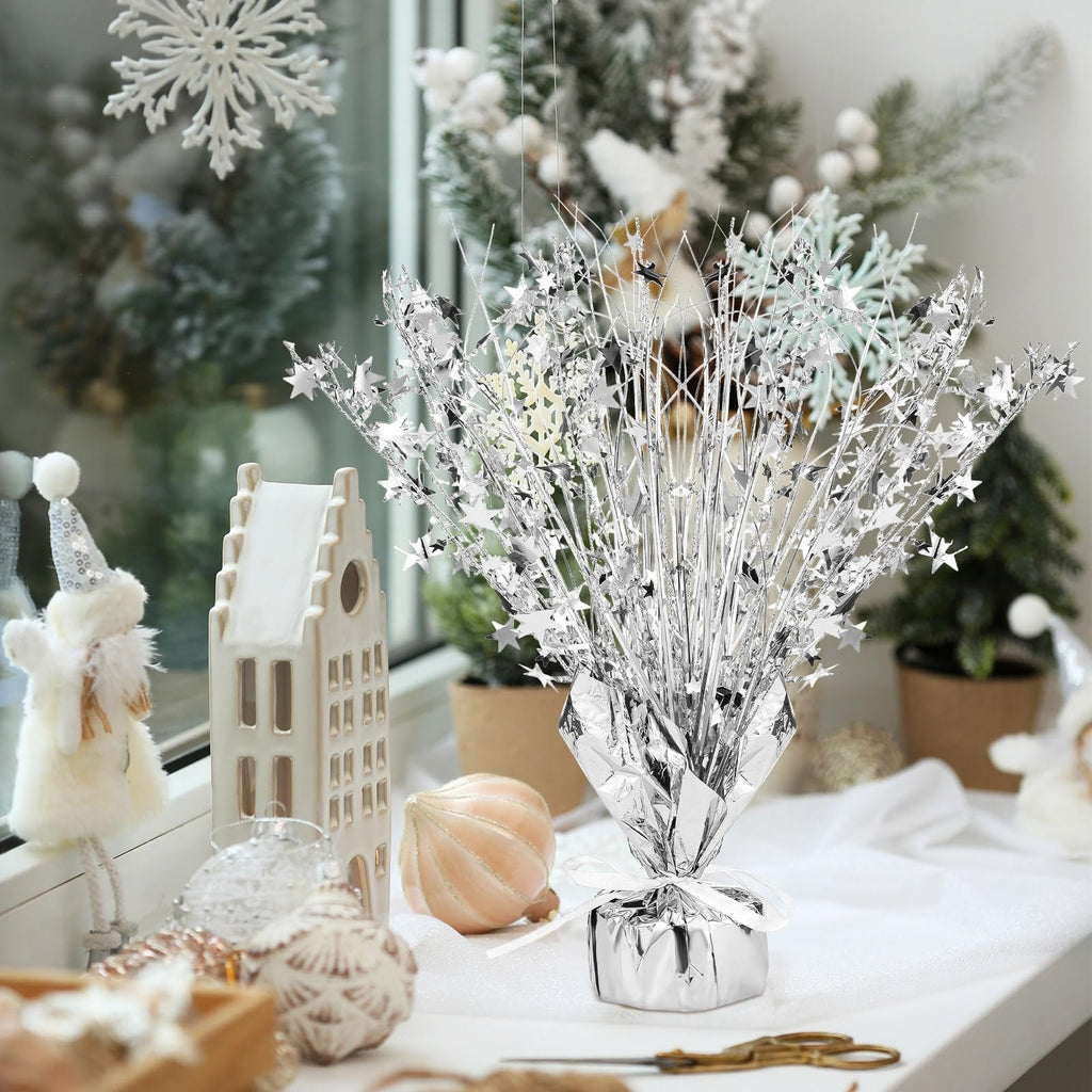 Silver metallic foil spray star burst centerpiece on a table with holiday decorations.
