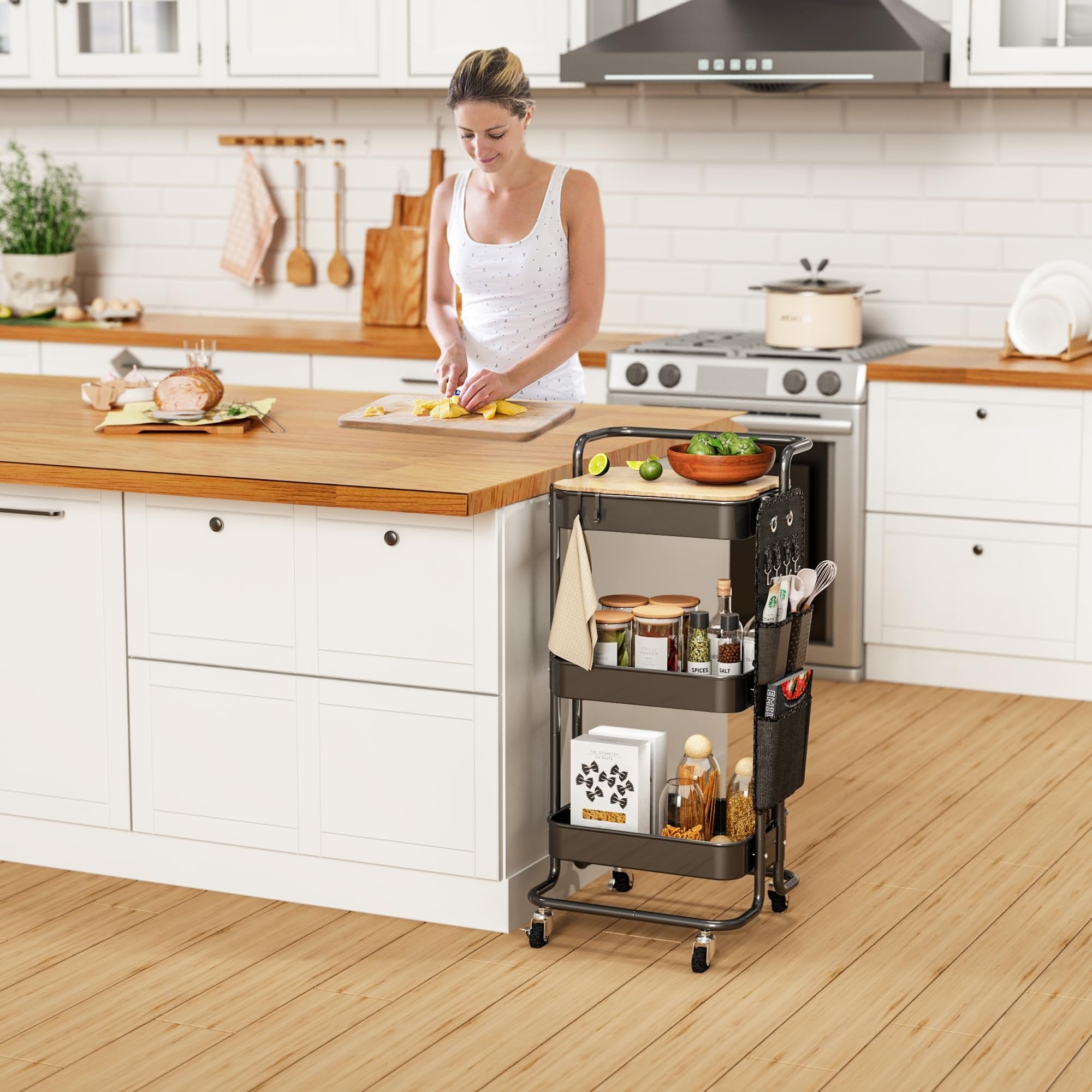 Woman preparing food in a kitchen next to a black three-tier rolling cart filled with groceries and kitchenware.
