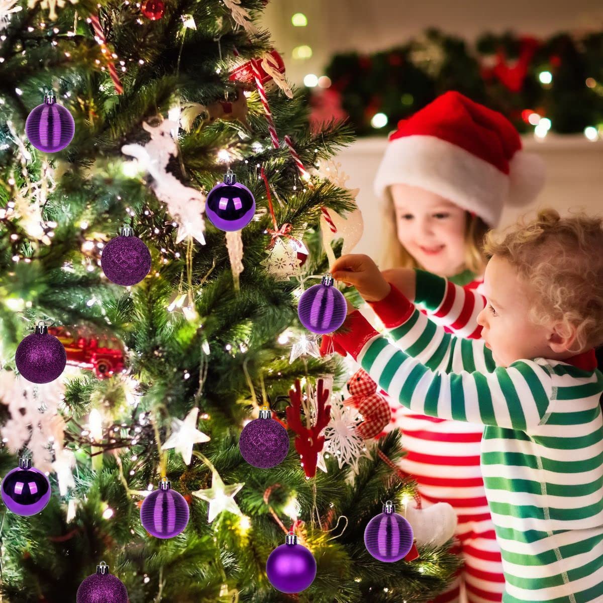 Two children decorating a Christmas tree with purple shatterproof ornaments.