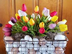 Arrangement of artificial tulips in a wire basket filled with decorative eggs and moss.