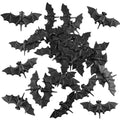 A collection of 30 small black 3D plastic bat decorations scattered against a white background.