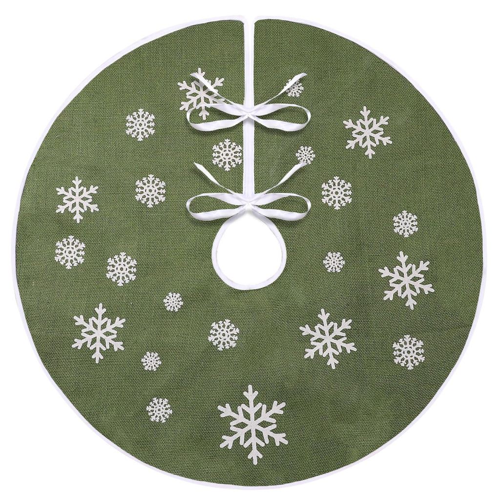Green burlap Christmas tree skirt with white snowflake print and white trim, tied with white ribbons.
