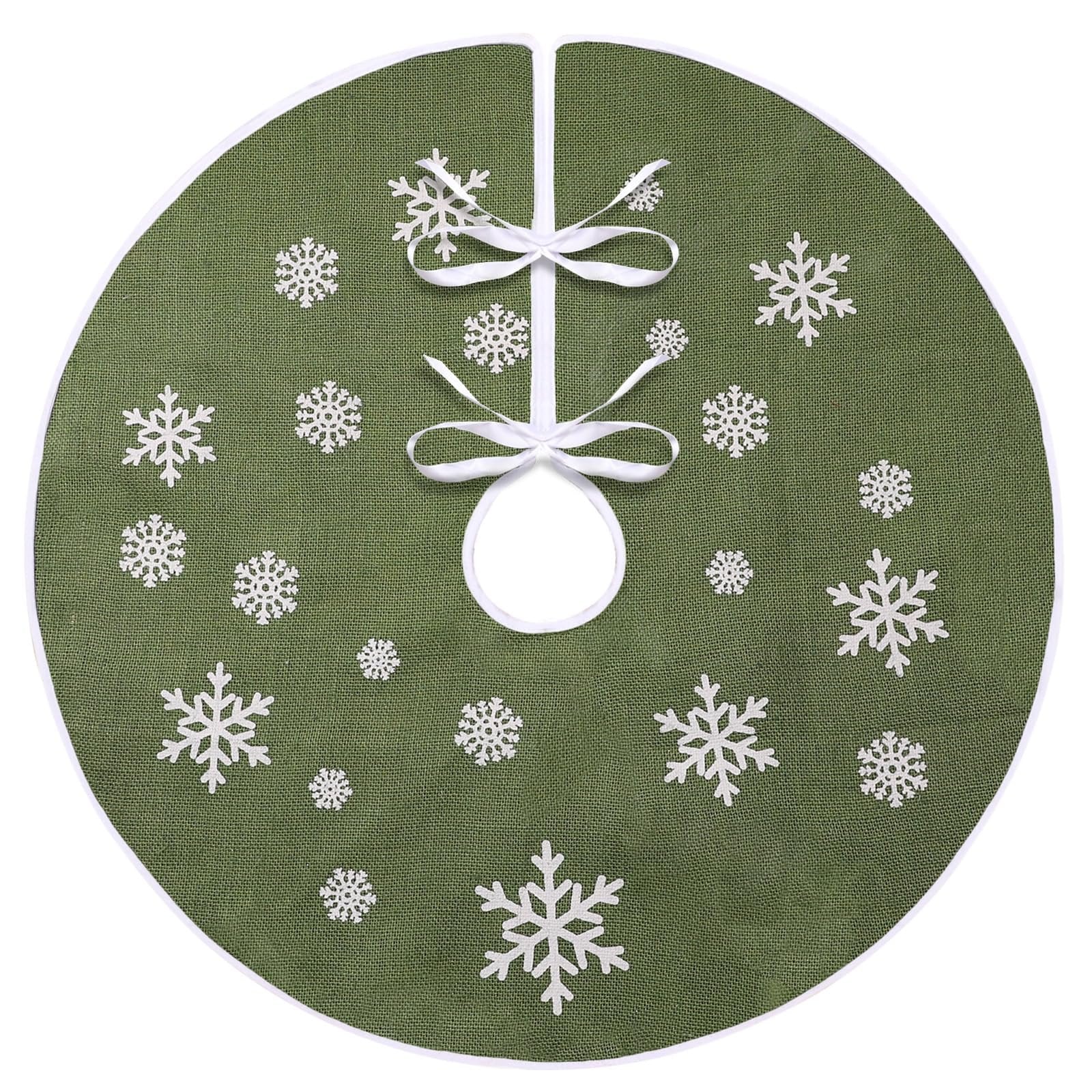 Green burlap Christmas tree skirt with white snowflake print and white trim, tied with white ribbons.