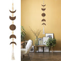 Wood moon phase wall hanging with beads and tassel, displayed in a room with plants and art.