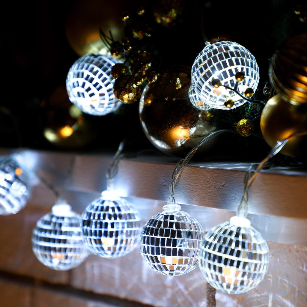 Close-up of string lights with small disco ball bulbs, illuminated against a dark background.