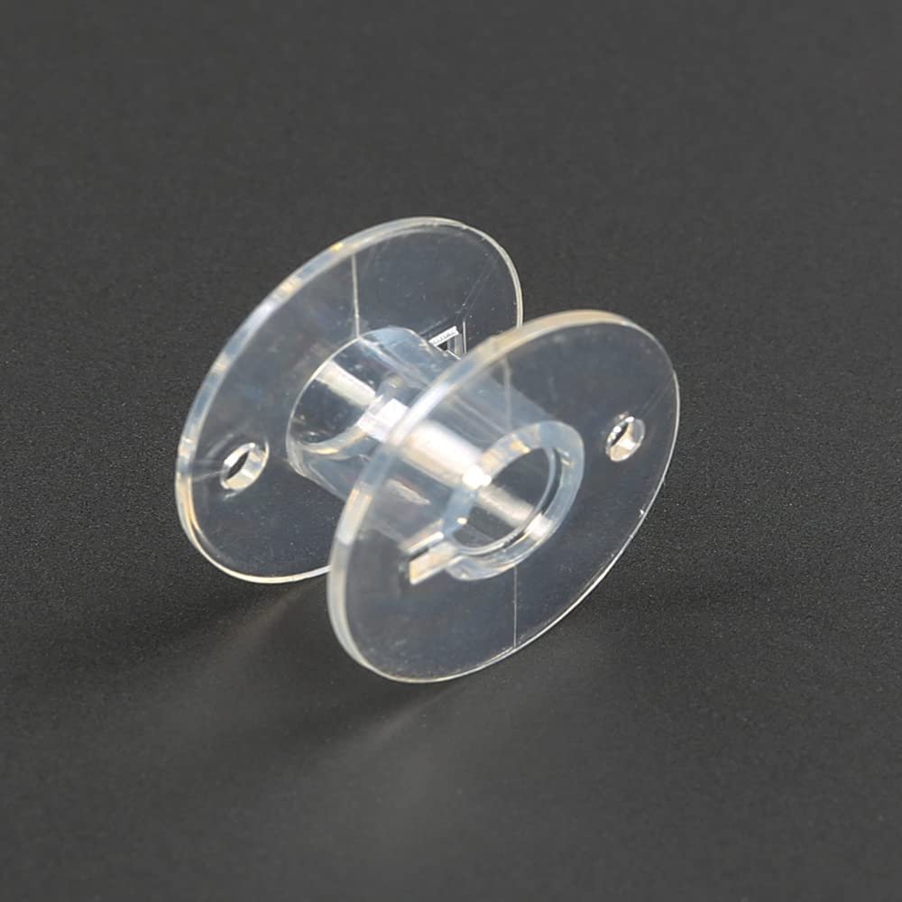Transparent plastic sewing machine bobbin shown from a side angle on a dark background.